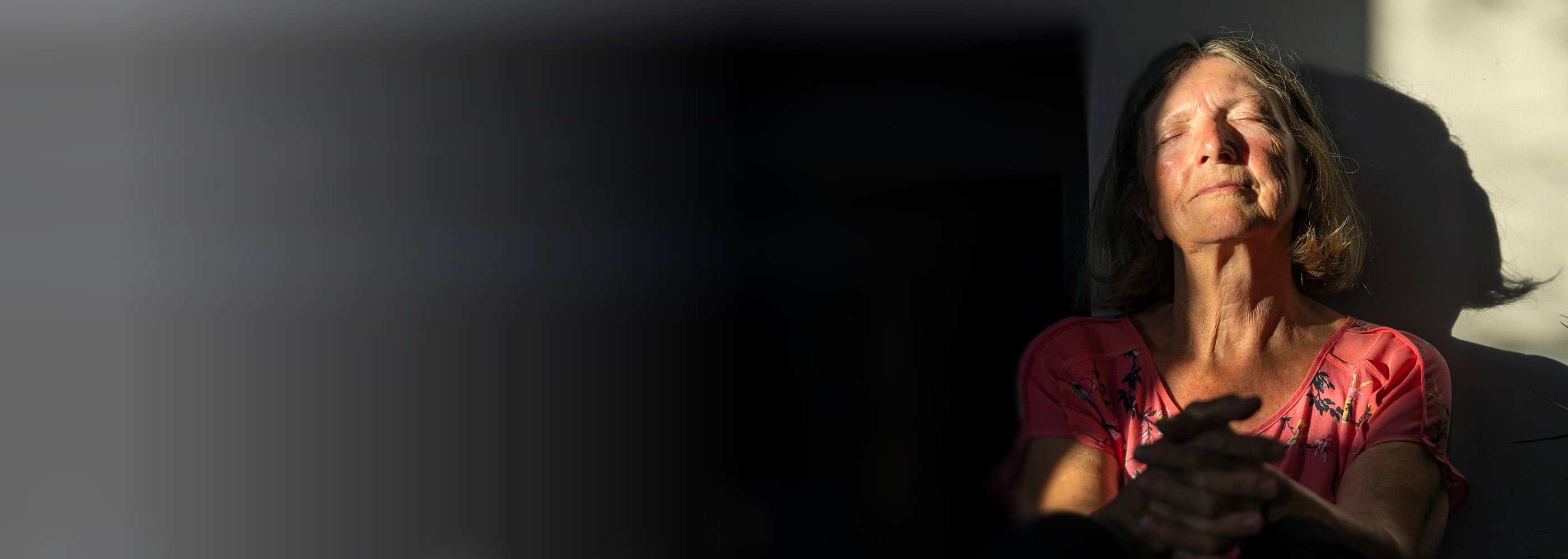 Eine ältere Dame mit Brille arbeitet an ihrem Tablet